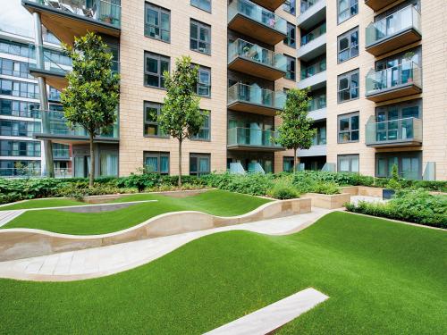 Courtyard with rolling mounds made from grass surrounded by residential blocks